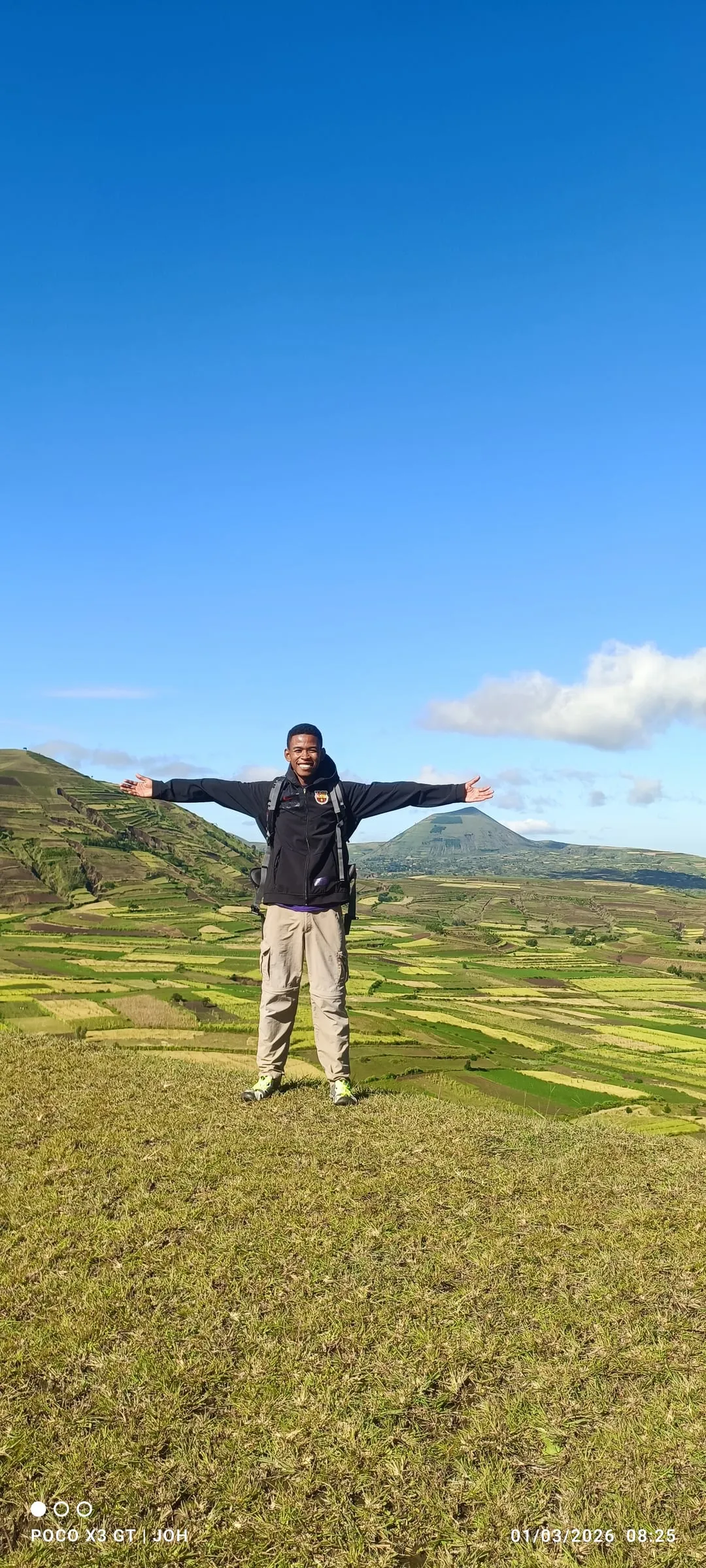 Our young local guide in Ampefy, arms wide open above the terraced fields